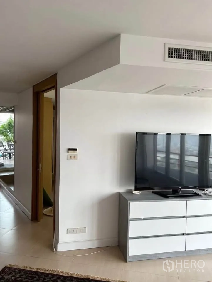 Condominium for rent or sale in Yan Nawa, Bangkok - Media corner with flat-screen TV on cabinet and sliding doors to view balcony.