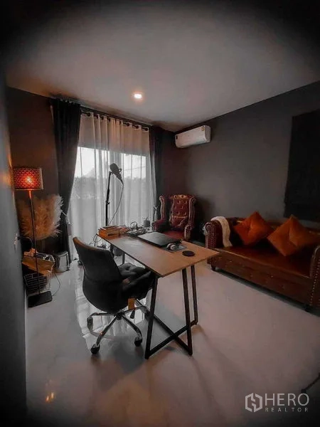 Detached House for rent in Bang Bo, Samut Prakan - Ground-floor home office with desk, leather sofa and full-height curtains.