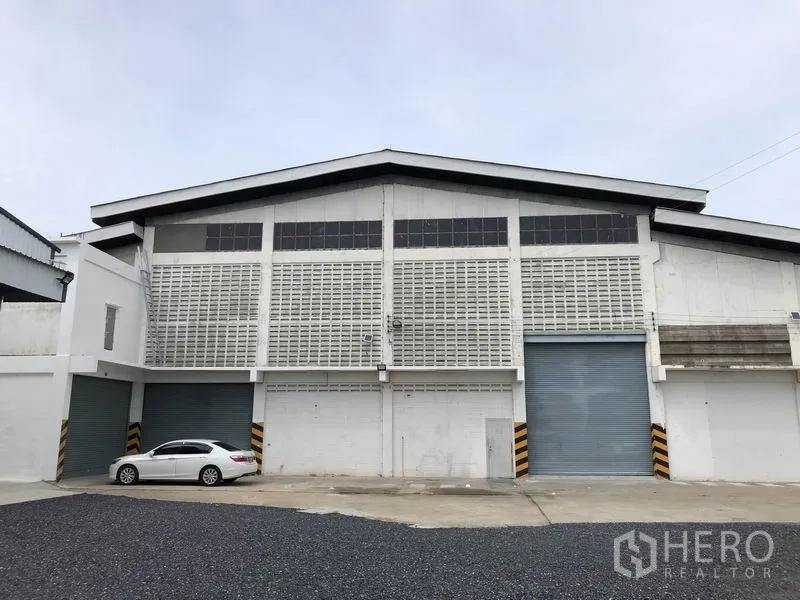 货栈 出租在Pathum Thani - 白色高层高仓库正立面，设多道卷帘门与停车场，位于Bang Kadi巴吞他尼。