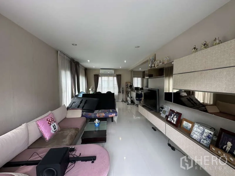 บ้าน ขายในSai Mai, Bangkok - ห้องนั่งเล่นยาว โปร่งสว่าง มีหน้าต่าง โซฟา และผนังทีวีบิวท์อิน