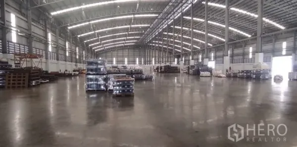 Warehouse for rent in Nong Chok, Bangkok - Expansive column-free storage hall with skylights and neatly stacked pallets on smooth concrete.