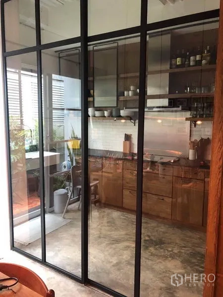 ทาวน์เฮาส์ ขายในWang Thonglang, Bangkok - ครัวกั้นด้วยประตูกระจกกรอบอลูมิเนียมสีดำ มองเห็นชานระเบียงเล็ก