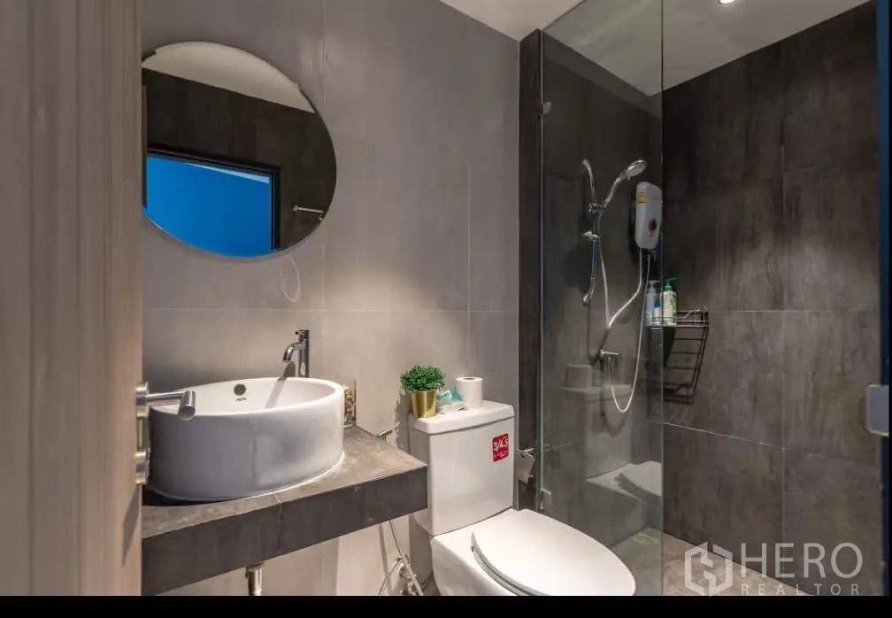 ทาวน์เฮาส์ for rent in Watthana, Bangkok - ห้องน้ำสไตล์โมเดิร์น มีอ่างล้างหน้าวางบนเคาน์เตอร์ โถสุขภัณฑ์ และตู้ชาวเวอร์กระจกพร้อมเครื่องทำน้ำอุ่น