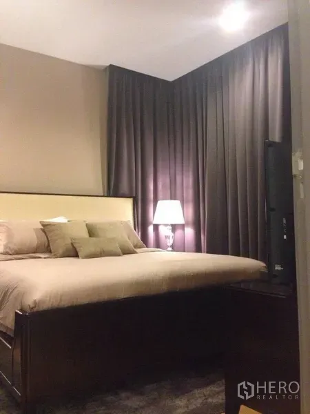 คอนโด ให้เช่าในKhlong Toei, Bangkok - ห้องนอนหลัก เตียงคิงไซซ์ โคมไฟหัวเตียง และผ้าม่านทึบเพื่อความเป็นส่วนตัว