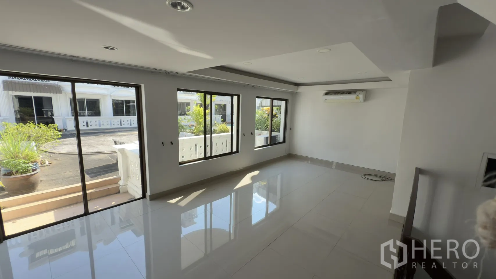 ทาวน์เฮาส์ for rent in Watthana, Bangkok - พื้นที่นั่งเล่นรับแสงแดด มีหน้าต่างบานเลื่อนหลายบานและระเบียงพร้อมกระถางต้นไม้