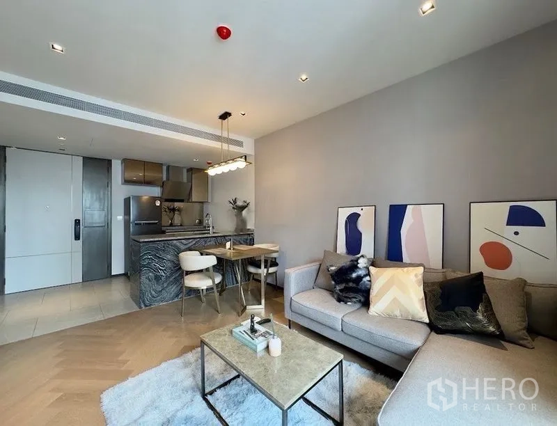 公寓 for rent or sale in Watthana, Bangkok - 开放式起居区，面向带石材中岛的厨房与用餐区。