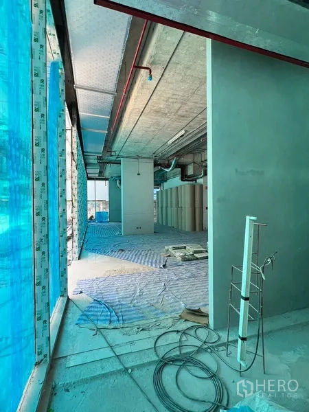 พื้นที่ขายปลีก ให้เช่าในKhlong Toei, Bangkok - ทางเดินข้างผนังกระจกสูงเชื่อมสู่โถงร้านค้าพร้อมงานระบบเปลือย