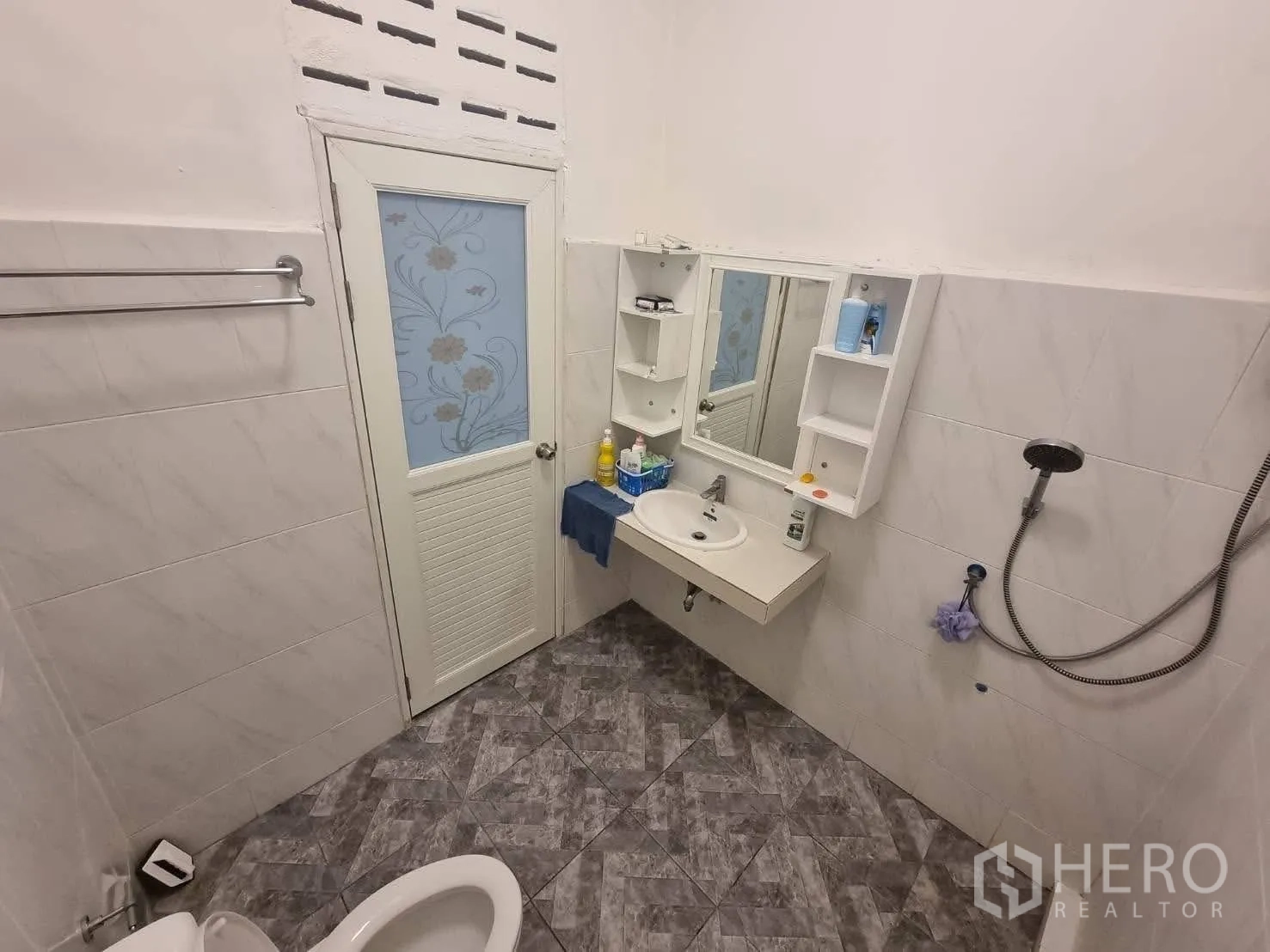 Townhouse for rent in Din Daeng, Bangkok - Corner bathroom with sink, storage shelves, mirror, shower and tiled floors.