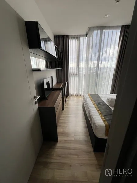 公寓 出租在Chatuchak, Bangkok - 卧室工作区，书桌、壁架及大窗城市景。