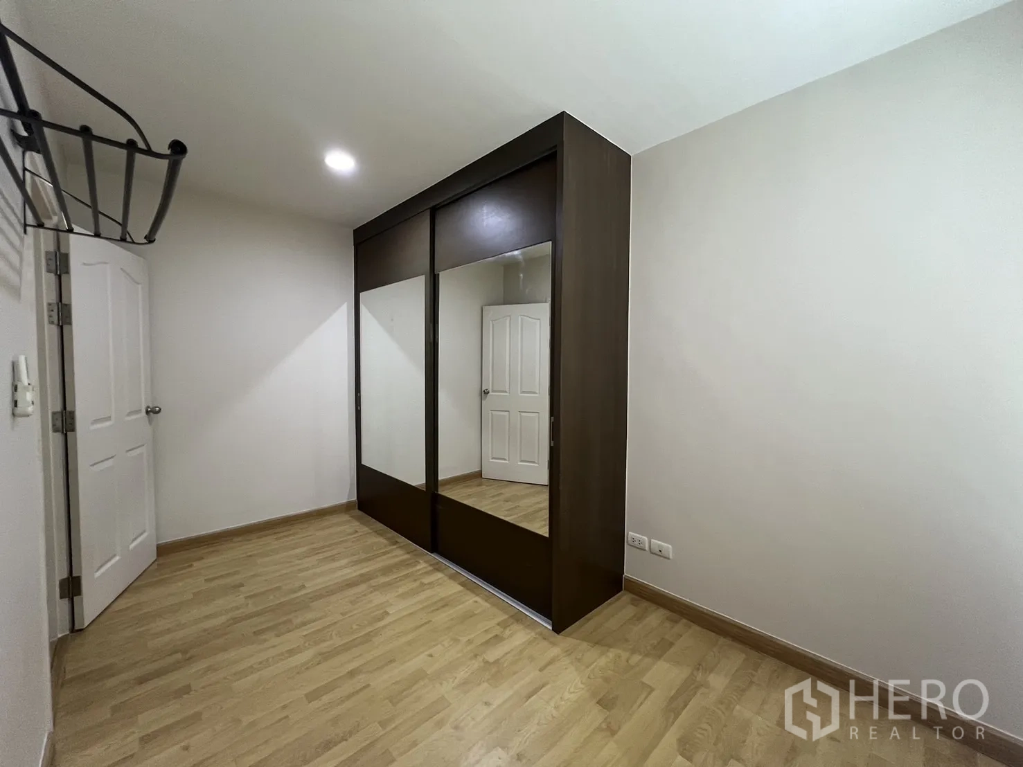 Townhouse for rent in Wang Thonglang, Bangkok - Guest bedroom with wood floors and large wardrobe.