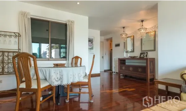 Condominium for rent in Pathum Wan, Bangkok - Cozy dining corner by the window with round table and pendant lights along the hallway.