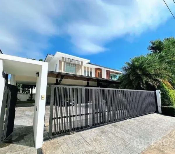 Detached House for rent or sale in Bang Phli, Samut Prakan - Modern two-storey detached house in Bang Phli with wide sliding black gate and paved driveway.