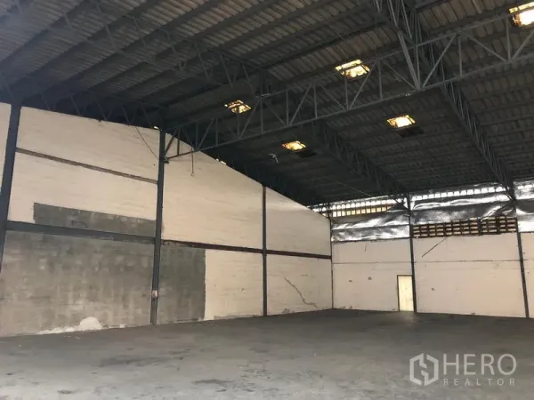 货栈 出租在Bang Phli, Samut Prakan - 空旷仓库内景，高钢结构屋顶与耐用混凝土地面。