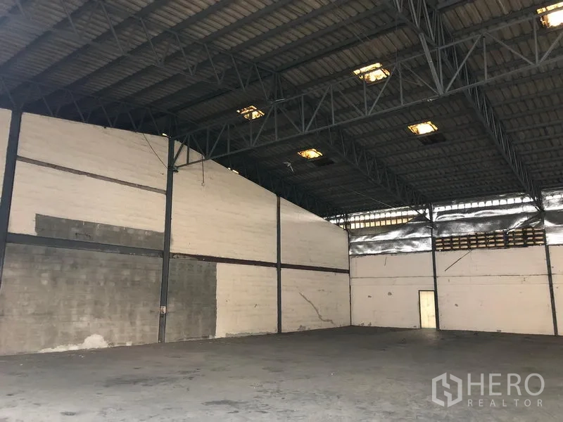 货栈 出租在Bang Phli, Samut Prakan - 空旷仓库内景，高钢结构屋顶与耐用混凝土地面。