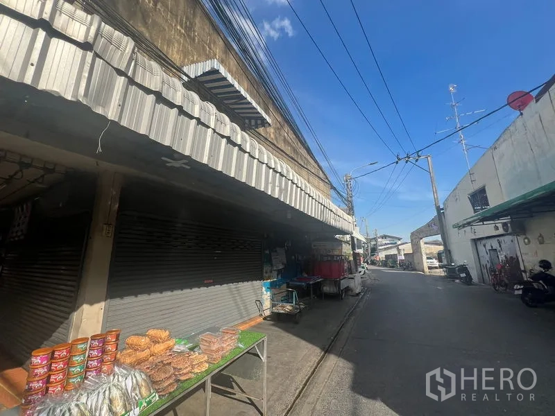 ที่ดิน ให้เช่าหรือขายในPhra Khanong, Bangkok - มุมทางเท้าข้างประตูกลิ้งปิดและร้านค้าข้างซอยแคบติดแนวตึกแถว.