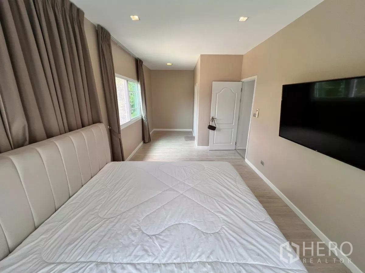 บ้าน ให้เช่าในLat Krabang, Bangkok - ห้องนอนใหญ่ ทีวีติดผนัง หน้าต่างบานกว้าง และโทนสีอบอุ่น