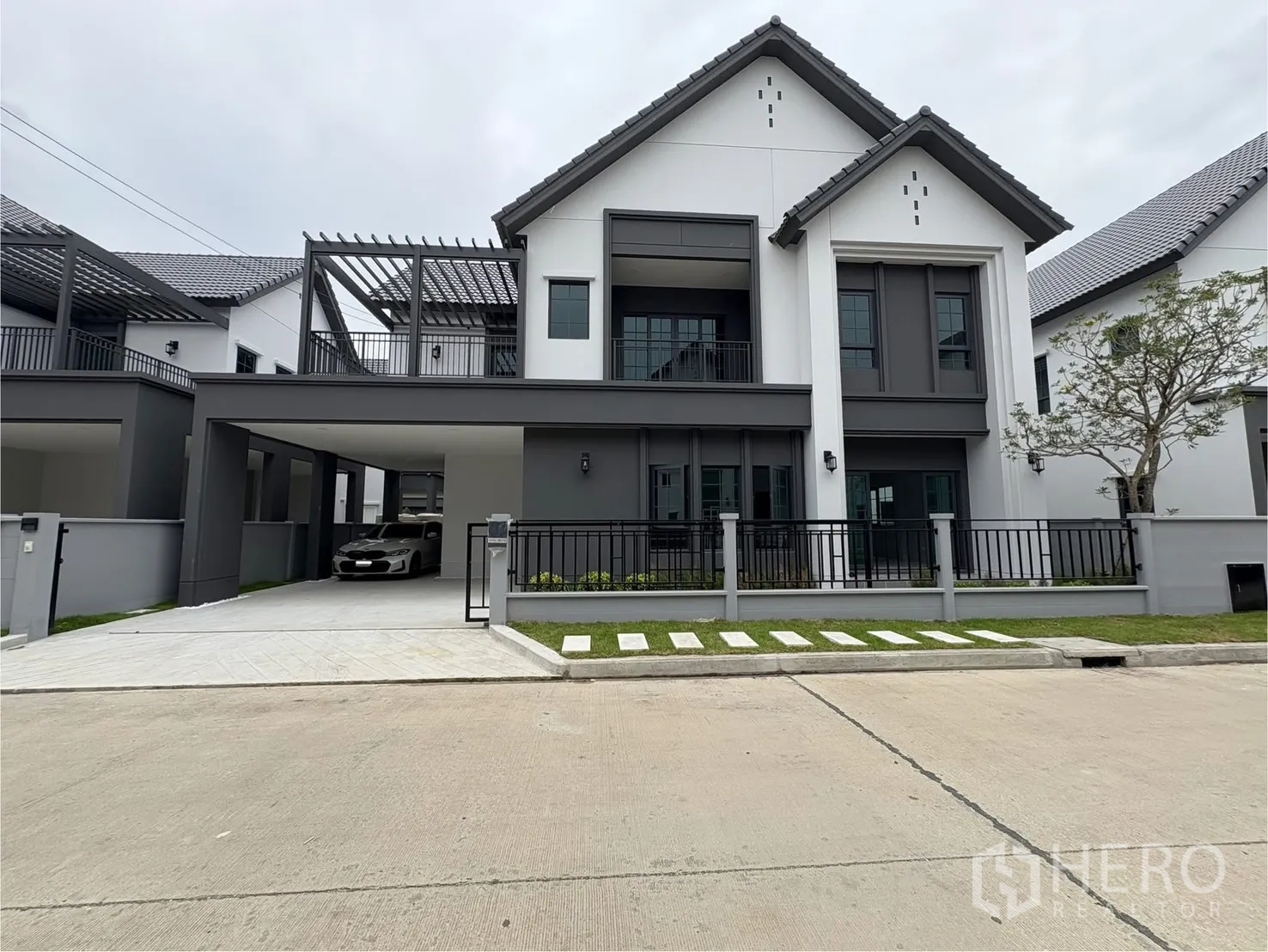 Detached House for rent in Bang Phli, Samut Prakan - Modern two-storey detached house exterior with covered carport, front lawn and fence.
