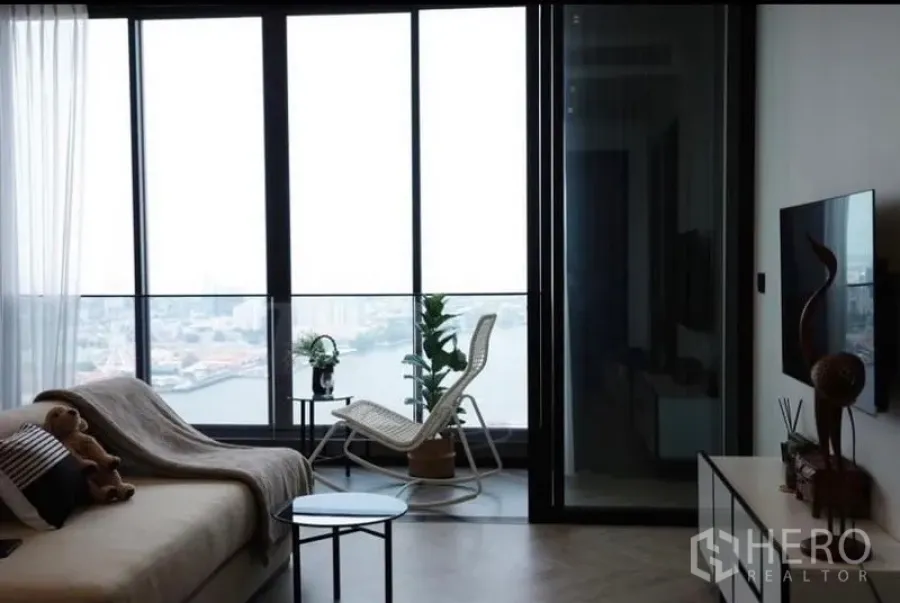 คอนโด ให้เช่า - ห้องนั่งเล่นกระจกพาโนรามาพร้อมประตูกระจกบานเลื่อนชมวิวแม่น้ำ