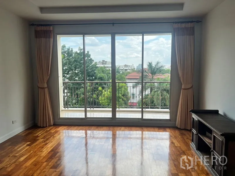 คอนโด ให้เช่าในSathon, Bangkok - พื้นที่นั่งเล่นมองออกสู่ระเบียงกระจก วิวสวน พื้นไม้เงางาม