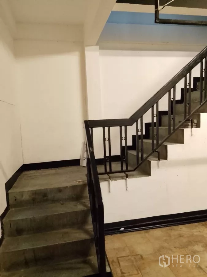 店屋 出租在Bang Rak, Bangkok - 下层混凝土楼梯与平台，黑色金属栏杆。