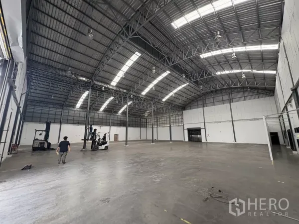 คลังสินค้า ให้เช่าในBang Phli, Samut Prakan - ภายในโกดังโล่งกว้าง โครงหลังคาเหล็ก ช่องแสงสกายไลท์ และพื้นคอนกรีตขัดมัน.
