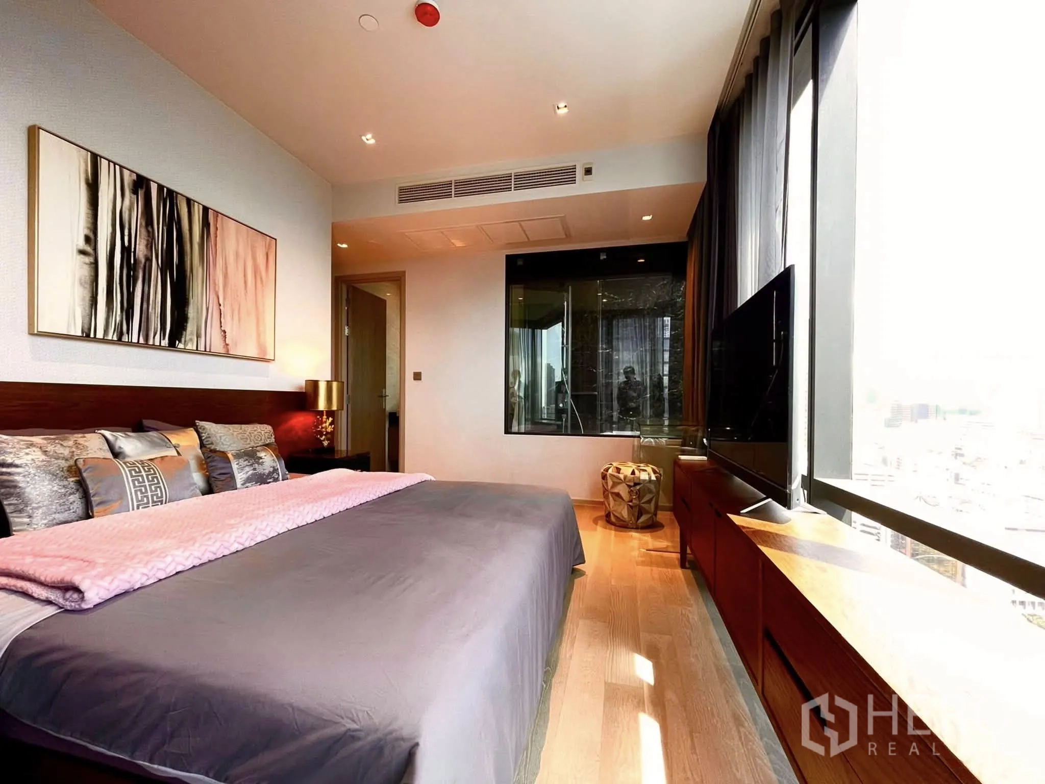 Condominium for rent in Bang Rak, Bangkok - Master bedroom with long window bench, glass panel and wood flooring.