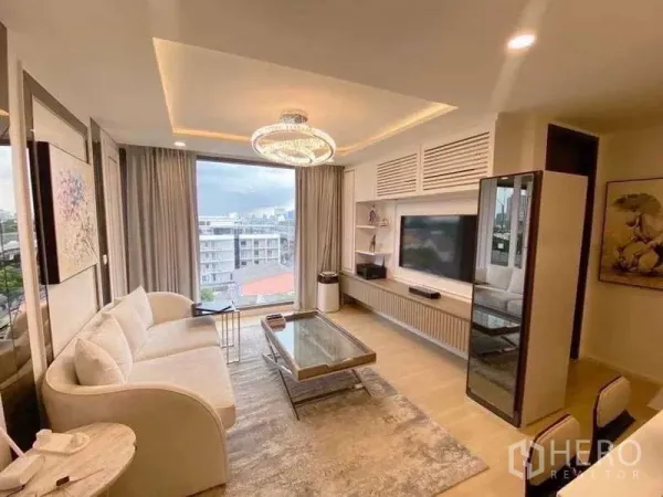 คอนโด ขาย - อีกมุมของห้องนั่งเล่นพร้อมโซฟา ผนังทีวี และหน้าต่างพาโนรามา