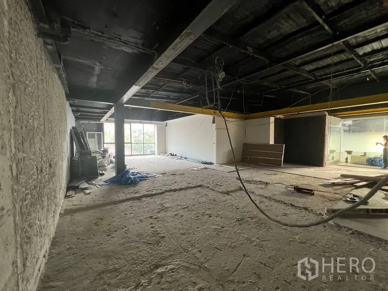 零售空间 出租在Watthana, Bangkok - 宽阔毛坯楼层，外露天花与悬挂线缆，尽头设窗。