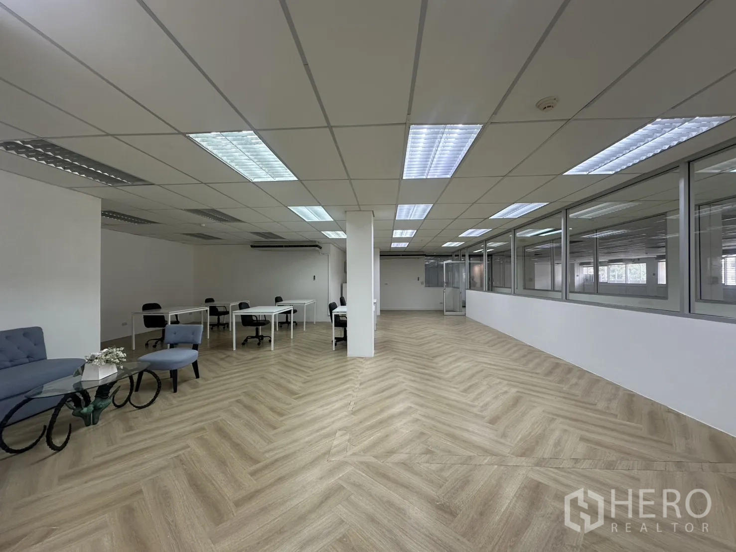 ออฟฟิศ for rent in Pathum Wan, Bangkok - พื้นที่สำนักงานกว้างพร้อมโต๊ะทำงาน มุมโซฟารับรอง และผนังกระจกภายใต้เพดานกริด