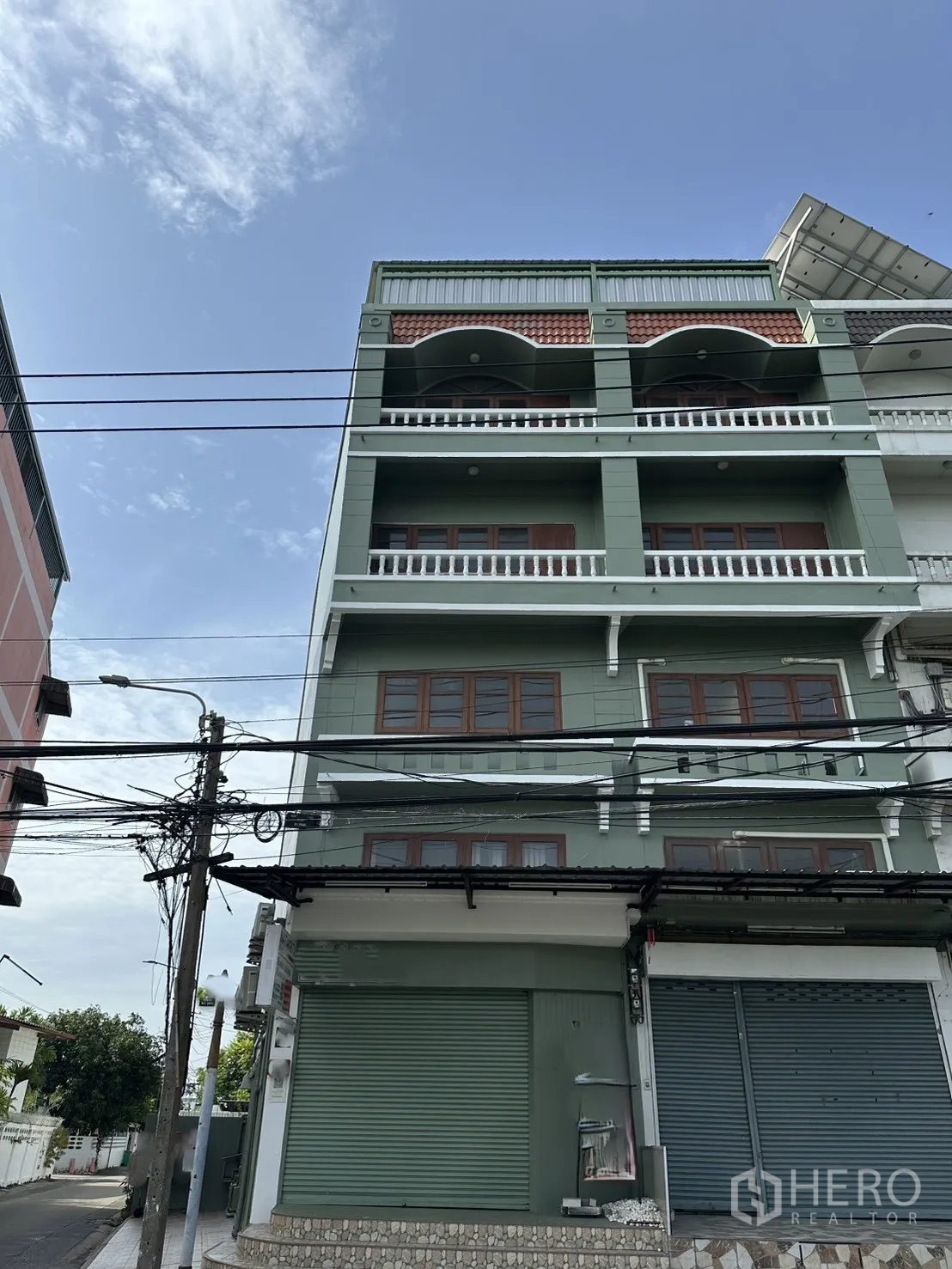 店屋 for rent in Phra Khanong, Bangkok - 多层绿色店屋外观，带阳台与卷闸门。