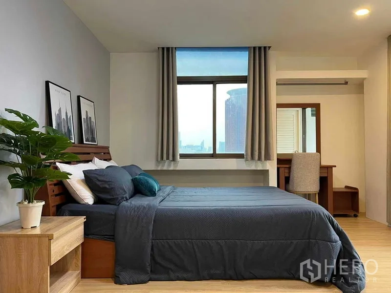 Condominium for rent in Ratchathewi, Bangkok - Spacious bedroom with desk, double bed in gray bedding, and a big window.