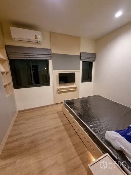 Townhouse for rent - Bedroom with two windows, air conditioner and a built-in TV niche above a floating shelf.