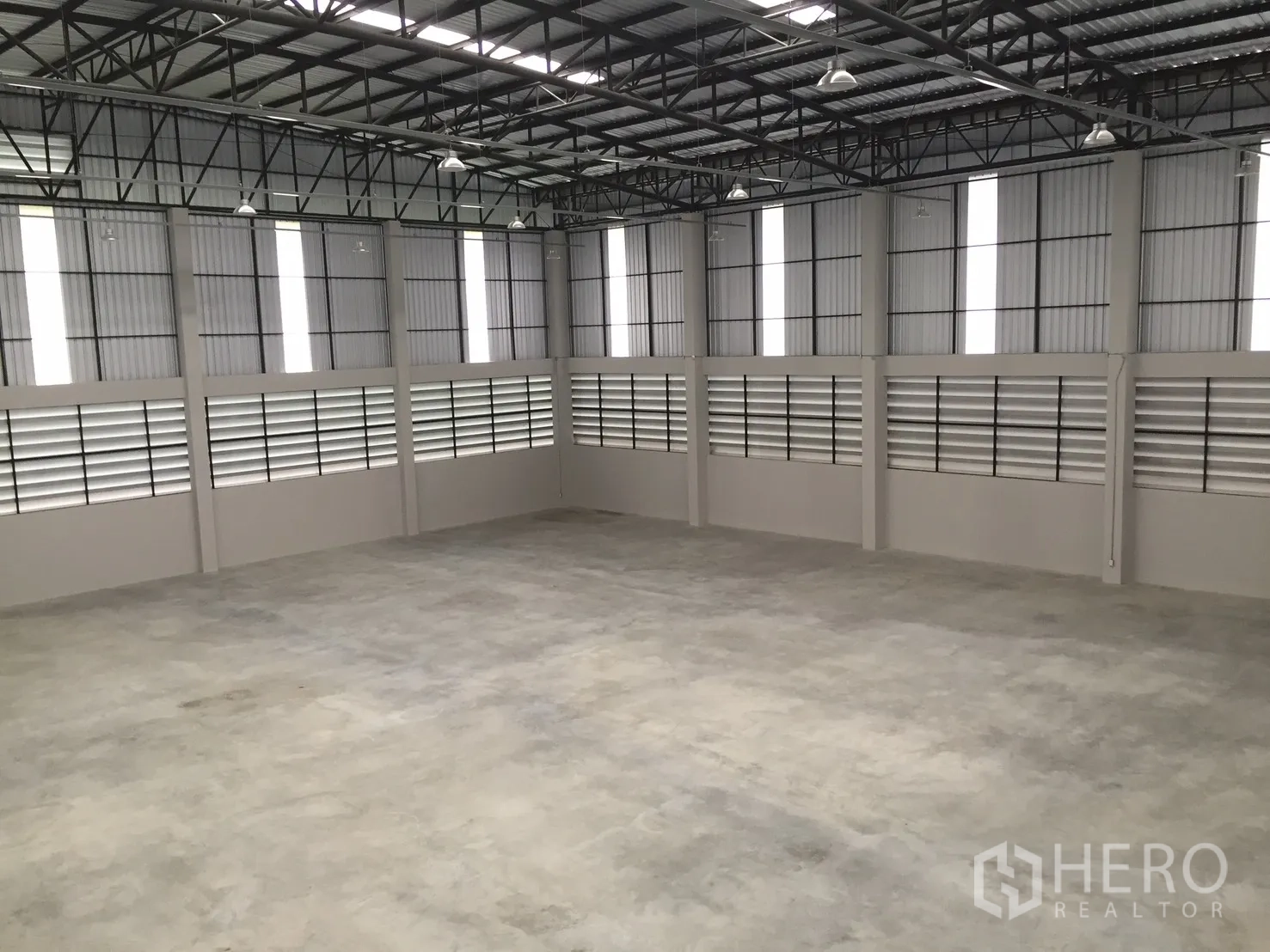 Warehouse for rent in Bang Phli, Samut Prakan - High-ceiling warehouse hall with concrete floor and ventilation louver panels.