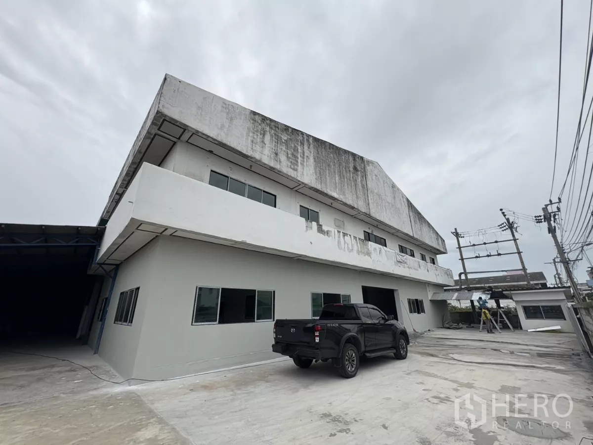 โรงงาน ให้เช่าในKhlong Toei, Bangkok - ด้านข้างตัวอาคารพร้อมลานคอนกรีตกว้างและงานทาสีกำลังดำเนินการ