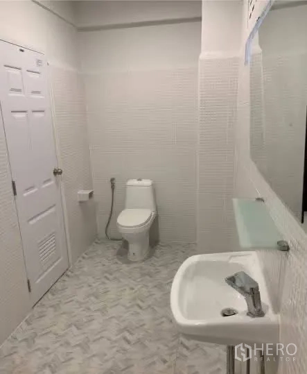 Home Office for rent in Sathon, Bangkok - Large white bathroom with sink, mirror, and toilet.