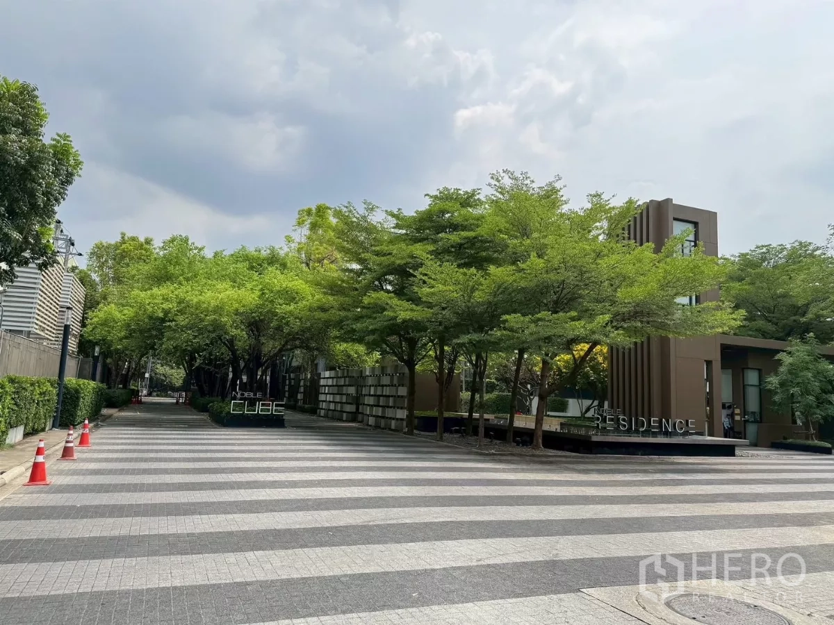 ทาวน์เฮาส์ ให้เช่าในSuan Luang, Bangkok - ทางเข้าโครงการ Noble Cube รายล้อมด้วยต้นไม้และป้ายโครงการ