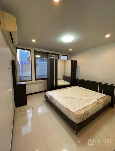 Shophouse for rent in Chatuchak, Bangkok - Bedroom with mattress, dark wardrobe set and large windows.