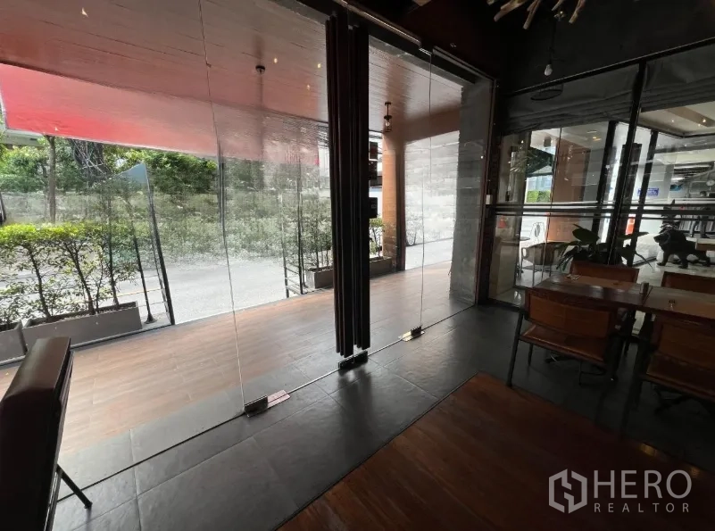 พื้นที่ขายปลีก ให้เช่าในWatthana, Bangkok - ประตูกระจกสูงเต็มผนังเปิดสู่พื้นที่นั่งด้านหน้าพร้อมต้นไม้