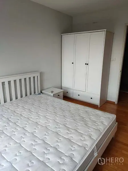 คอนโด ขายในKhlong Toei, Bangkok - ห้องนอนที่สองพร้อมเตียงสีขาว ตู้เสื้อผ้า โต๊ะข้าง พื้นไม้