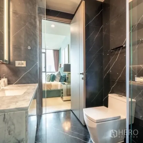 คอนโด ให้เช่าหรือขายในWatthana, Bangkok - ห้องน้ำสมัยใหม่ปูกระเบื้องหินอ่อนสีดำ พร้อมตู้กระจก ฝักบัว และเคาน์เตอร์หินอ่อน มีประตูเชื่อมห้องนอน