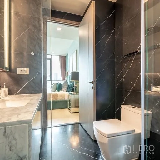 คอนโด ให้เช่าหรือขายในWatthana, Bangkok - ห้องน้ำสมัยใหม่ปูกระเบื้องหินอ่อนสีดำ พร้อมตู้กระจก ฝักบัว และเคาน์เตอร์หินอ่อน มีประตูเชื่อมห้องนอน