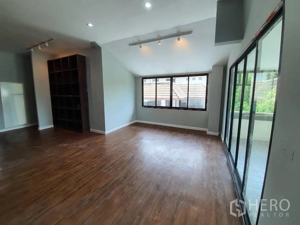 Home Office for rent in Wang Thonglang, Bangkok - Bright office area with wood floors, wide windows and sliding glass doors to a balcony.