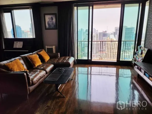 Condominium for sale in Khlong Toei, Bangkok - Bright living room with leather sofa, piano and balcony overlooking the Bangkok skyline.