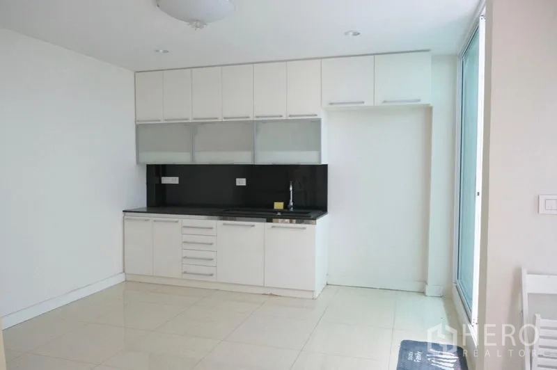 ทาวน์เฮาส์ ให้เช่าในKhlong Toei, Bangkok - ครัวสีขาวกะทัดรัด แผงหลังสีดำ ตู้ลอย และอ่างล้างจาน