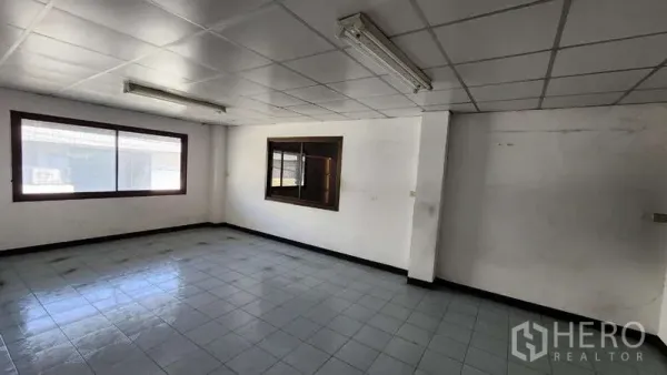Warehouse for rent in Nong Khaem, Bangkok - Bright upstairs office room with large window, white ceiling tiles, and ceramic floor.