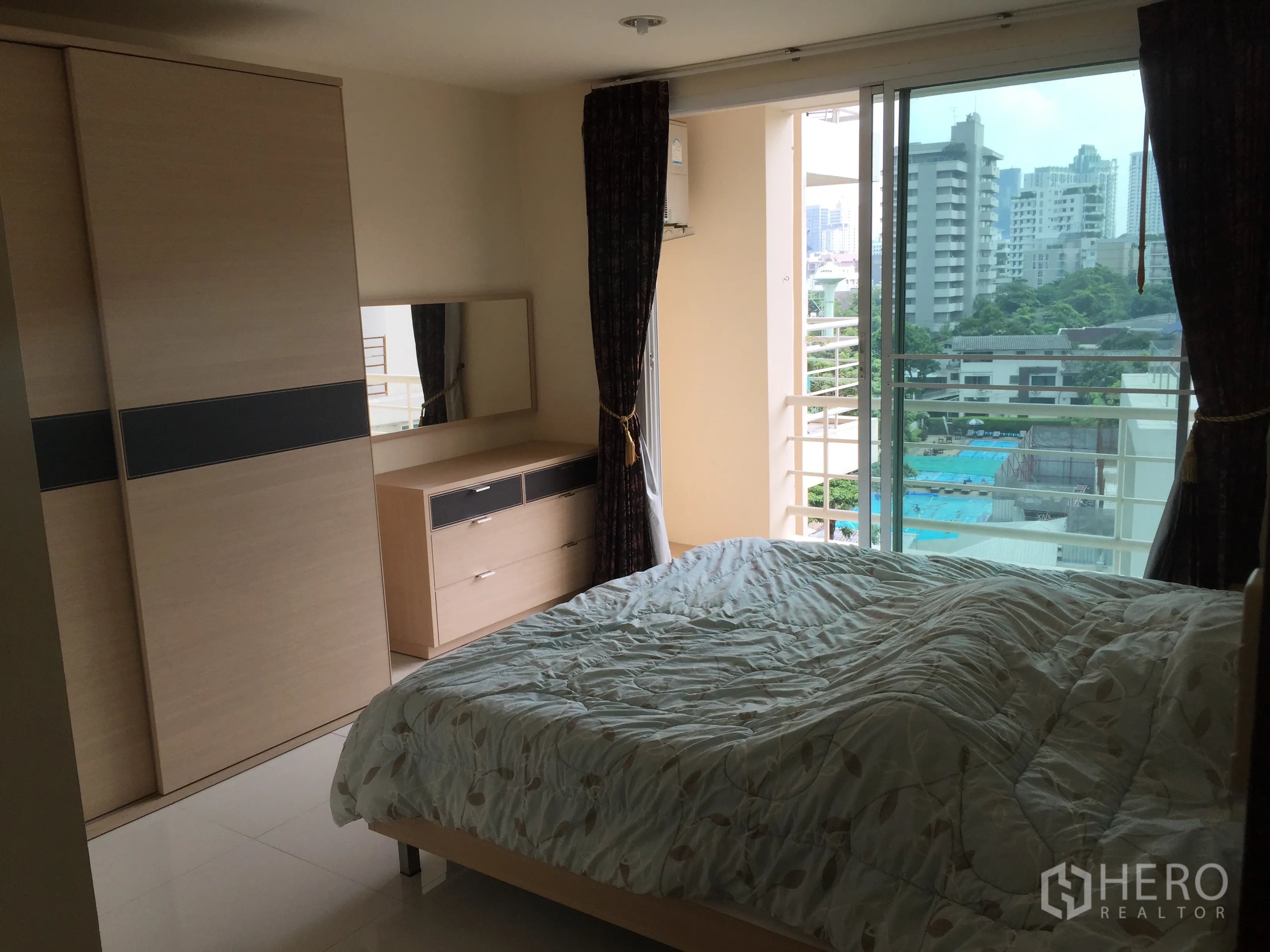 คอนโด ให้เช่าหรือขายในWatthana, Bangkok - ห้องนอนเปิดสู่ระเบียงมองเห็นสระว่ายน้ำและอาคารในเมือง