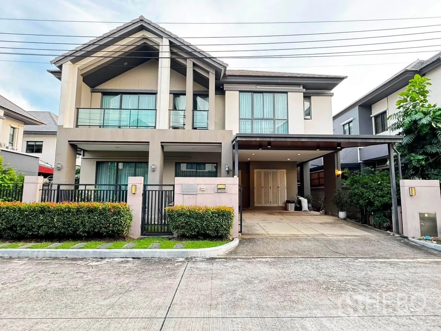 独栋房屋 for rent in Saphan Sung, Bangkok - 现代两层独栋住宅，带入户围栏、绿篱与有顶车位。