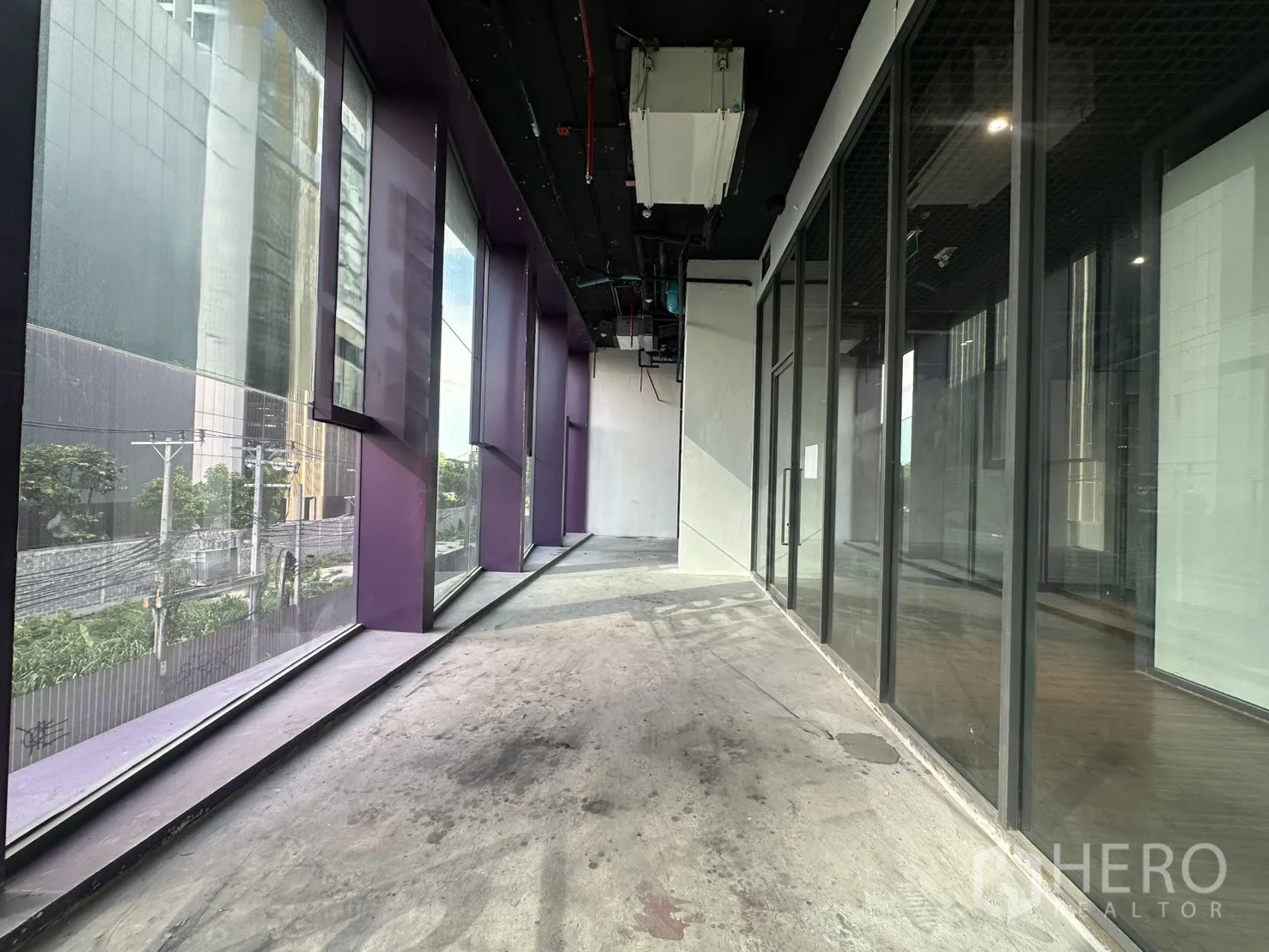 Retail Space for rent in Khlong Toei, Bangkok - Narrow window bay with purple frames facing the street and adjoining glass wall.