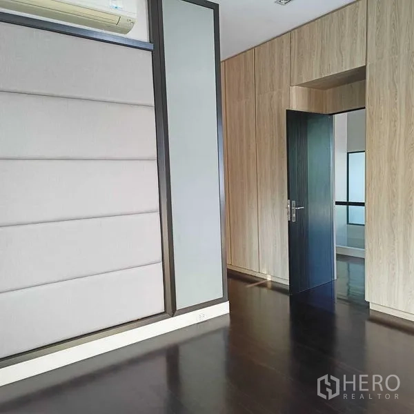 独立式住宅 出租或出售在Mueang Nonthaburi, Nonthaburi - 楼上房间带软包装饰墙与深色木地板。