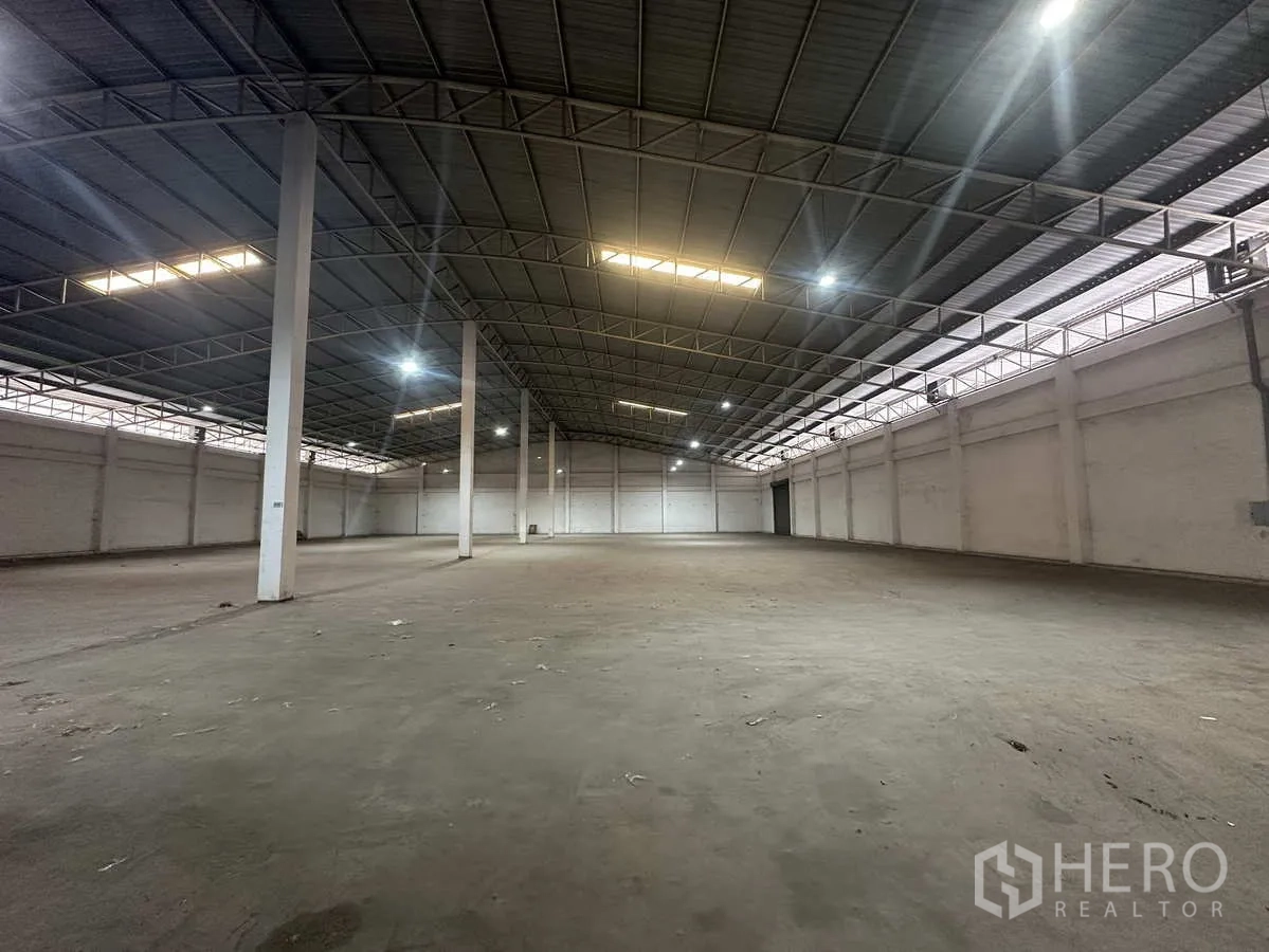 货栈 出租在Phra Nakhon Si Ayutthaya - 开敞库区，钢桁架、采光带与LED灯沿屋脊布置。